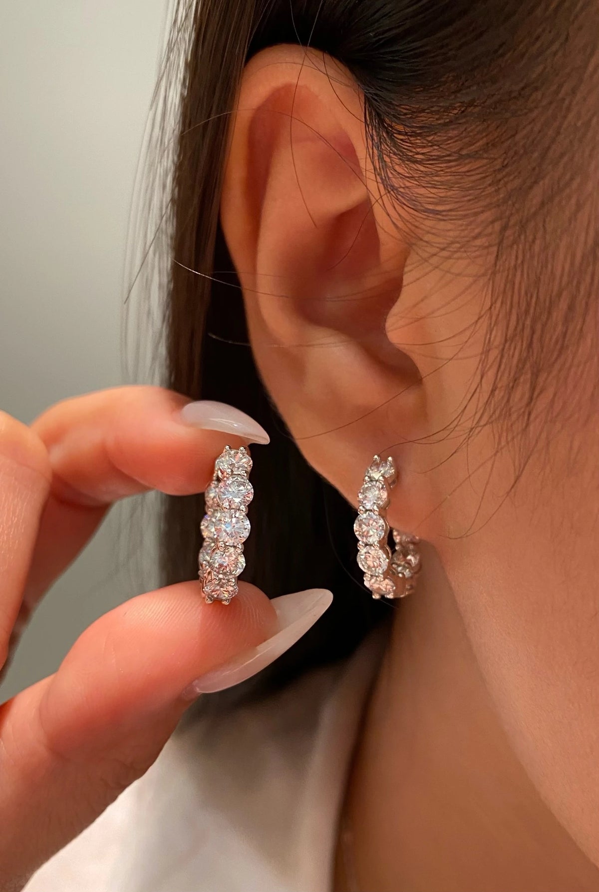 Round diamond hoop earrings shown worn and held for a size comparison, view 1