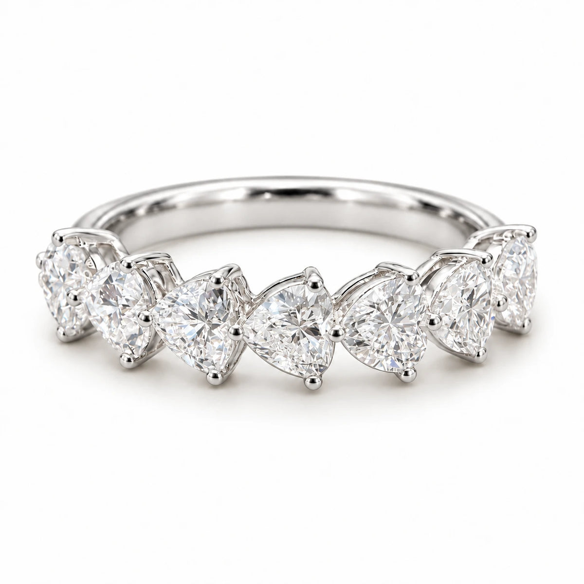 Seven heart-cut lab-grown diamonds set in an 18K white gold band on white background