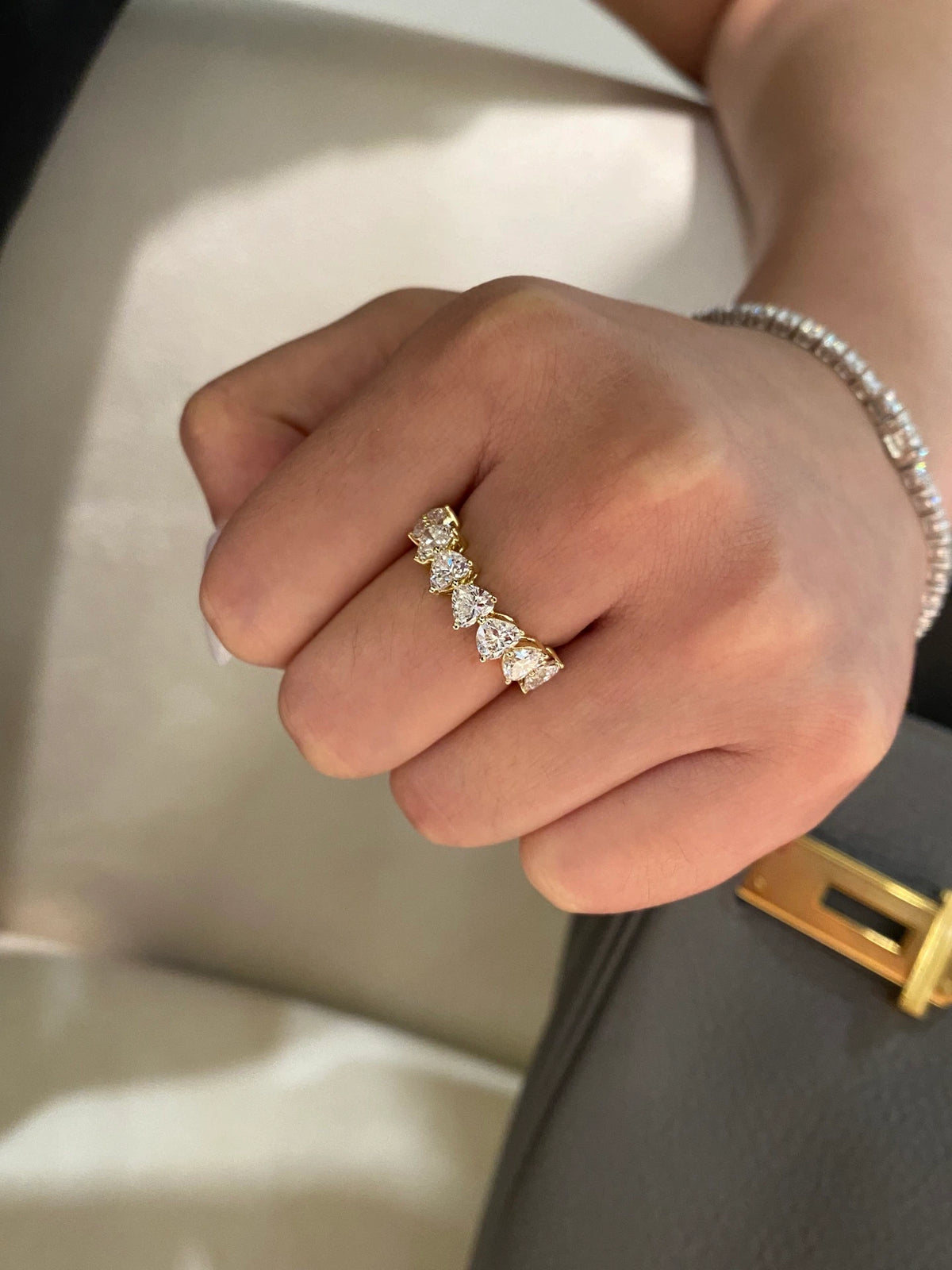 Heart-cut diamond band in 18K yellow gold worn on a hand, original view 5