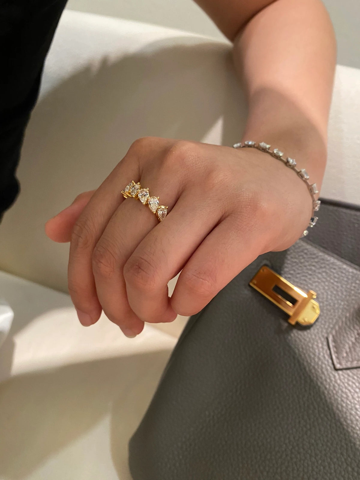 Pear-cut diamond band in 18K yellow gold worn on a hand, original view 9