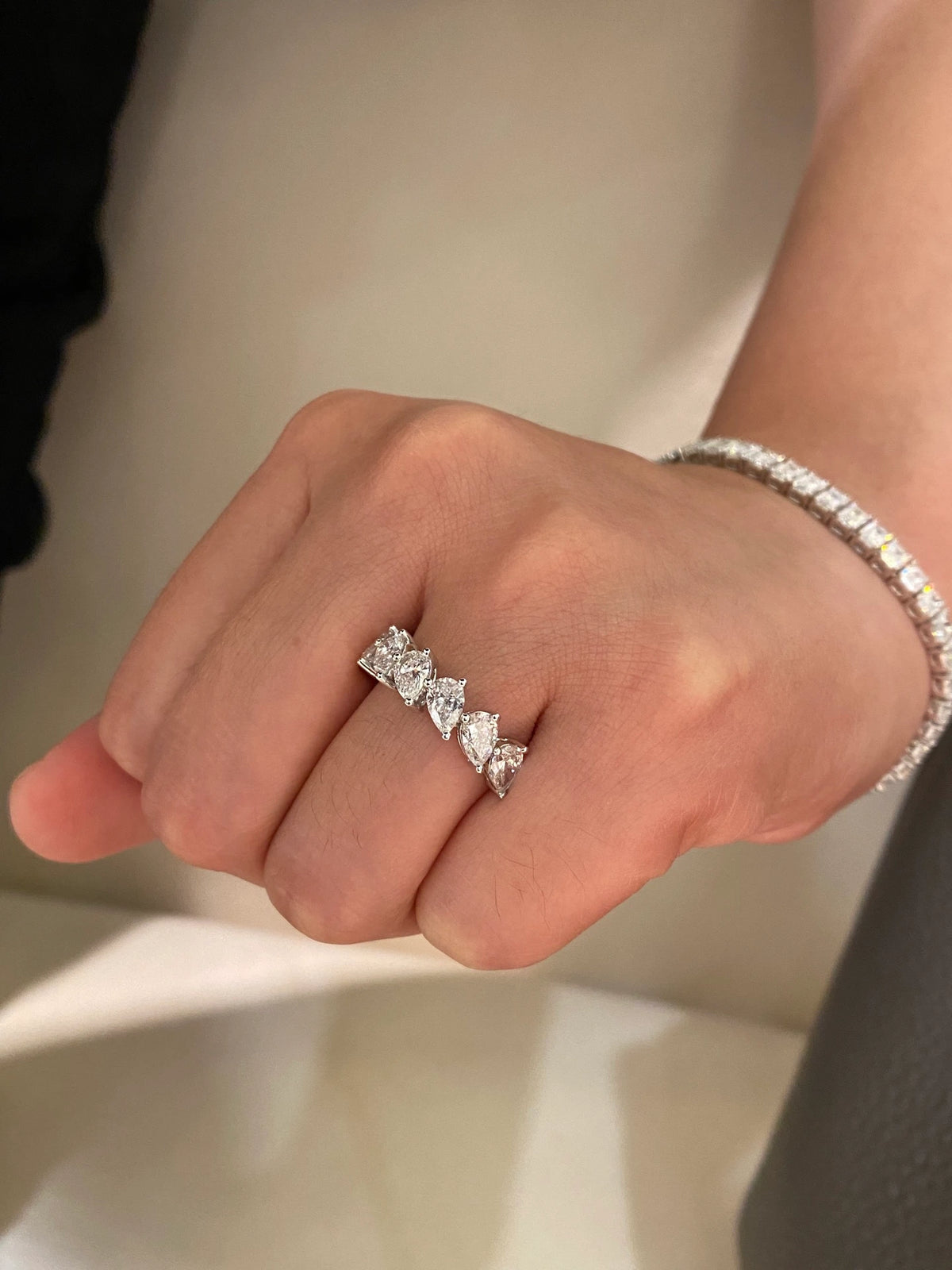 Pear-cut diamond band in 18K white gold worn on a hand, original view 6