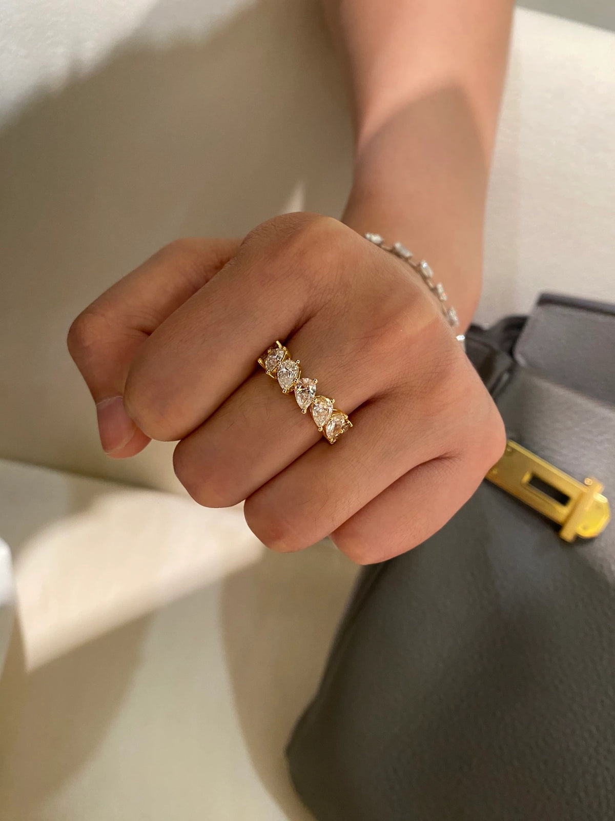 Pear-cut diamond band in 18K yellow gold worn on a hand, original view 8