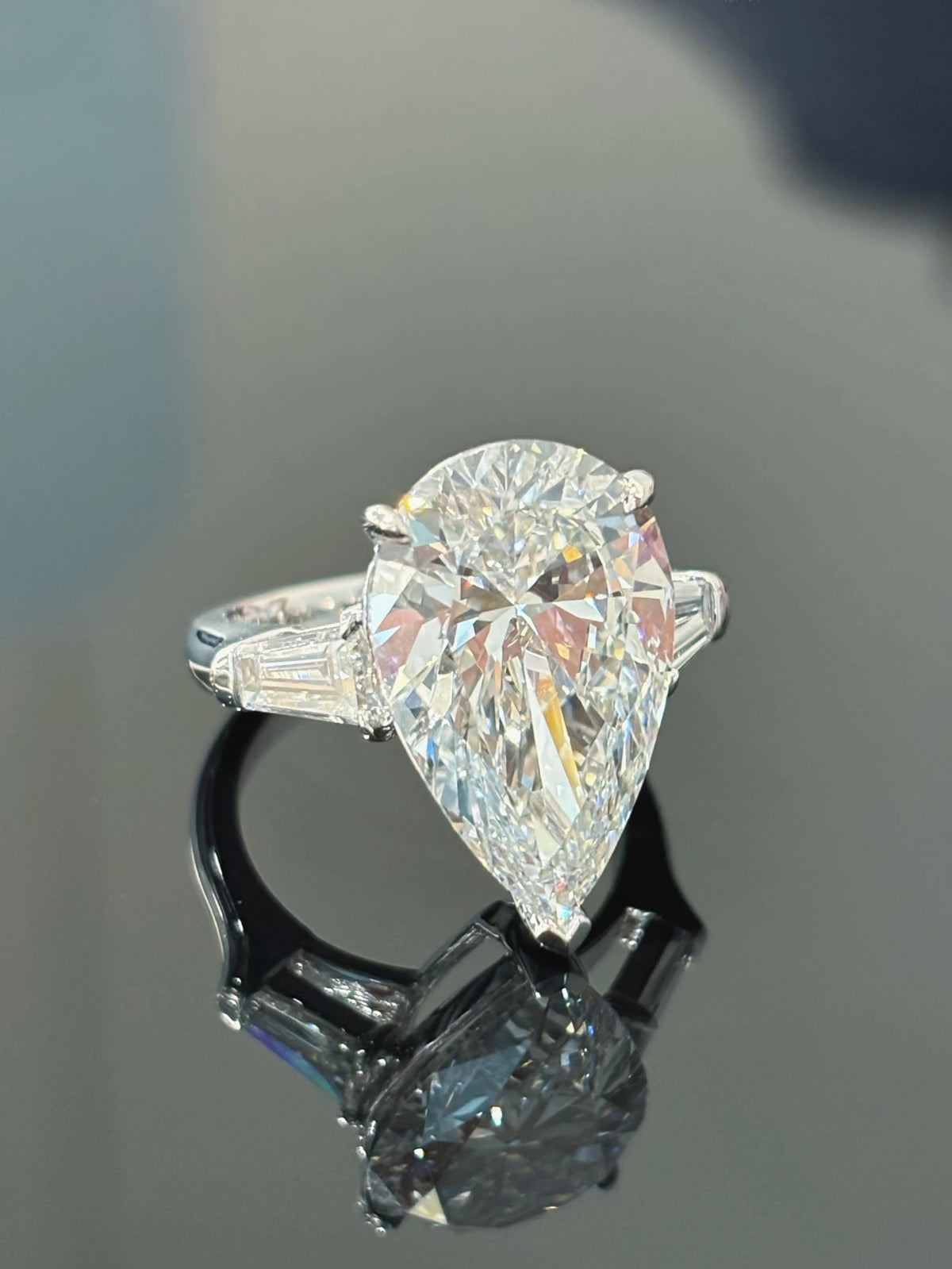 Pear-cut diamond ring with tapered baguette side stones in 18K white gold, original view 1