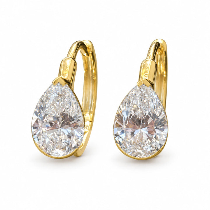 Pair of pear-cut lab-grown diamond earrings in 18K yellow gold on white background