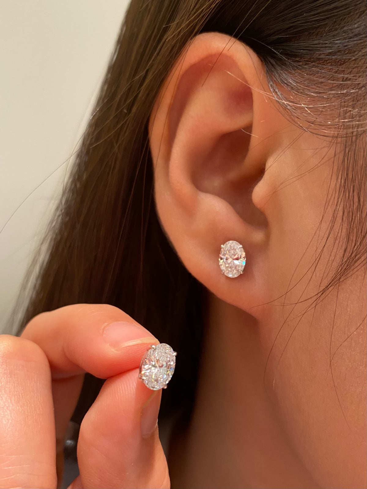 Oval-cut lab-grown diamond stud earrings in 18K white gold, original wearing view 1