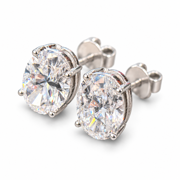 Pair of oval-cut lab-grown diamond stud earrings in 18K white gold on white background