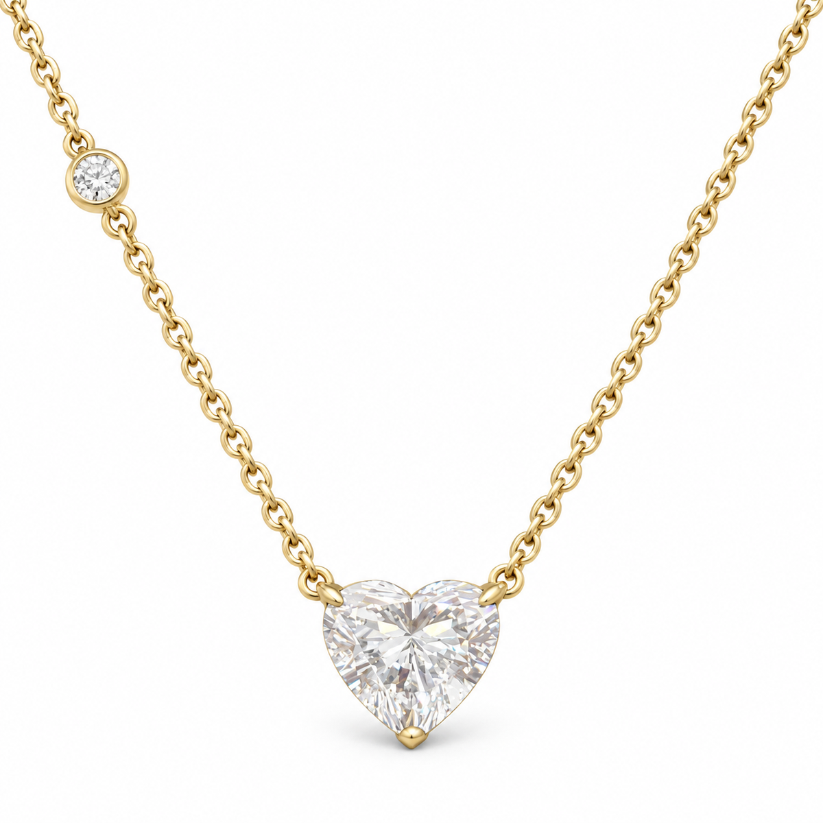 Heart-cut lab-grown diamond necklace in 18K yellow gold with a round diamond accent on white background