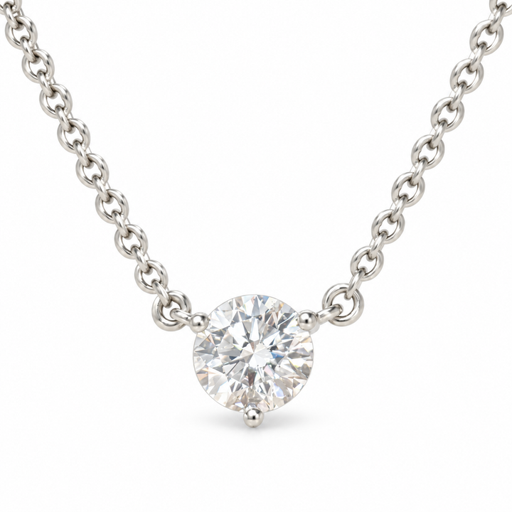 Round solitaire lab-grown diamond in an 18K white gold three-prong necklace, white background