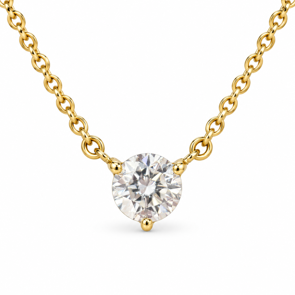 Round solitaire lab-grown diamond in an 18K yellow gold three-prong necklace, white background
