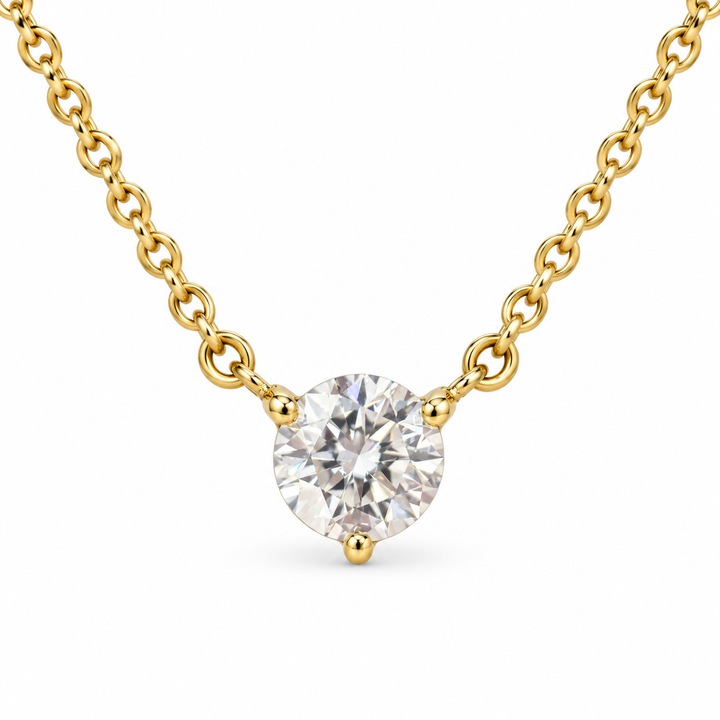 Round solitaire lab-grown diamond in an 18K yellow gold three-prong necklace, white background