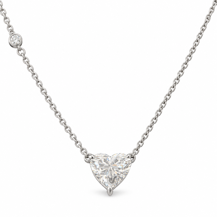 Heart-cut lab-grown diamond necklace in 18K white gold with one round diamond accent on white background