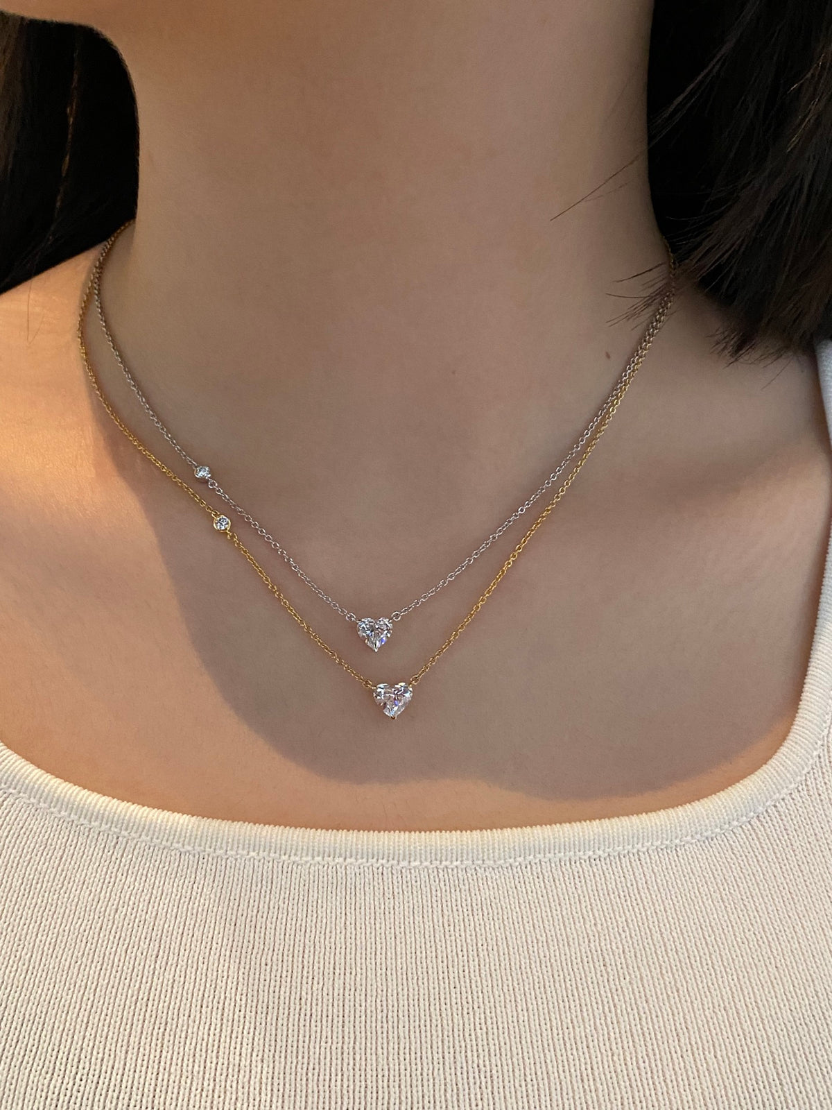 Layered styling with 18K yellow and white gold heart necklaces, each sold individually