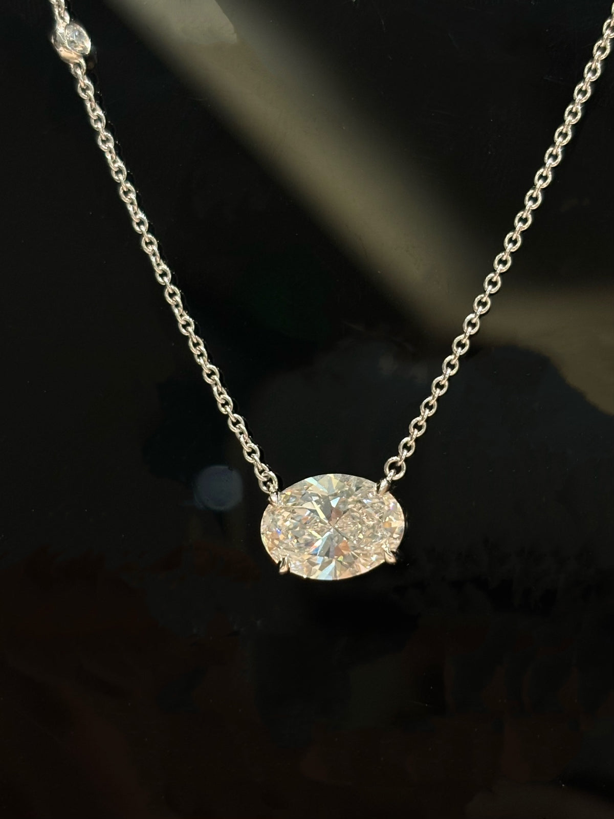 East-west oval lab-grown diamond necklace with one round diamond accent, original detail view 2
