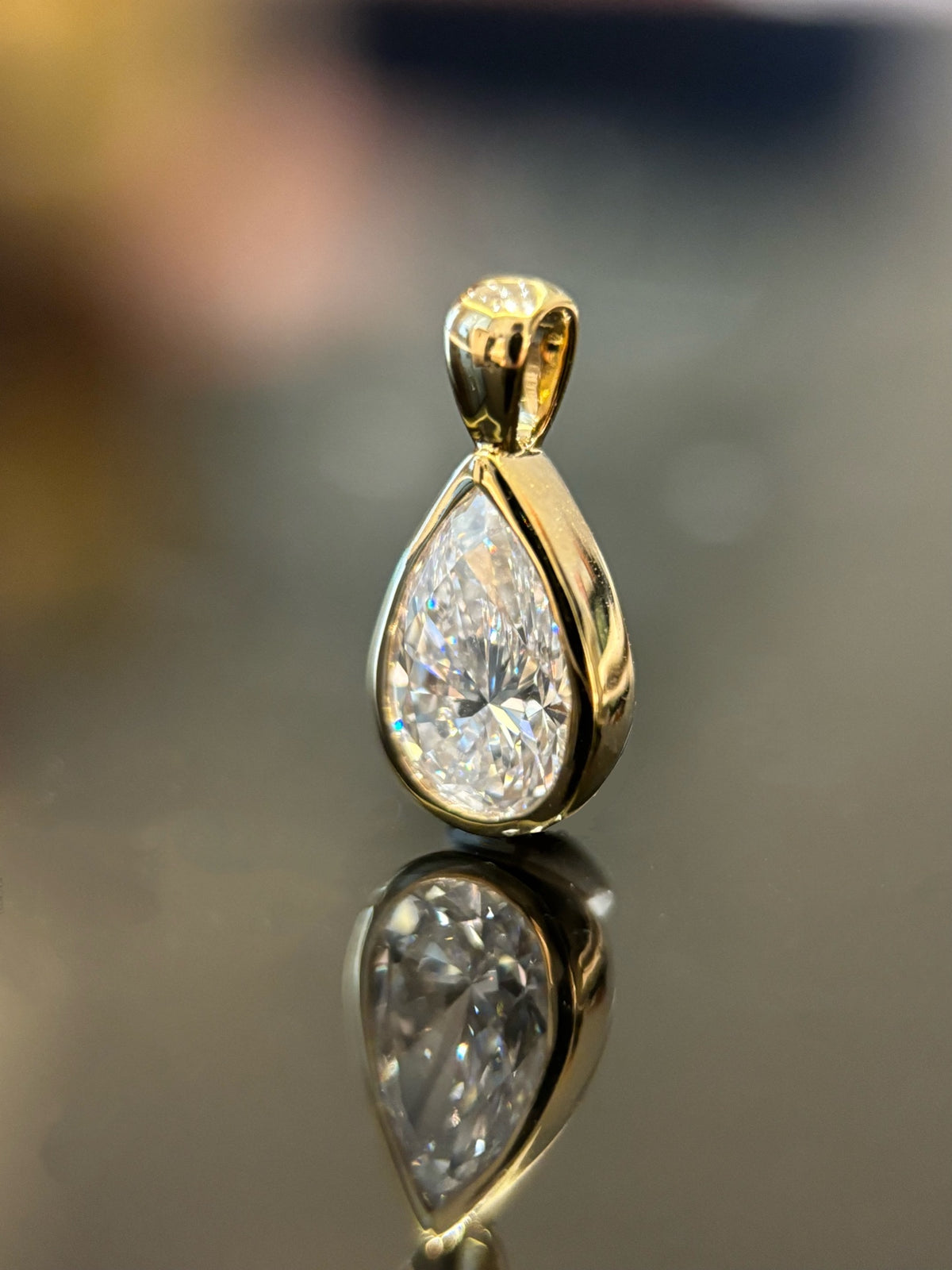 Pear bezel lab-grown diamond pendant in yellow metal, original angled detail view