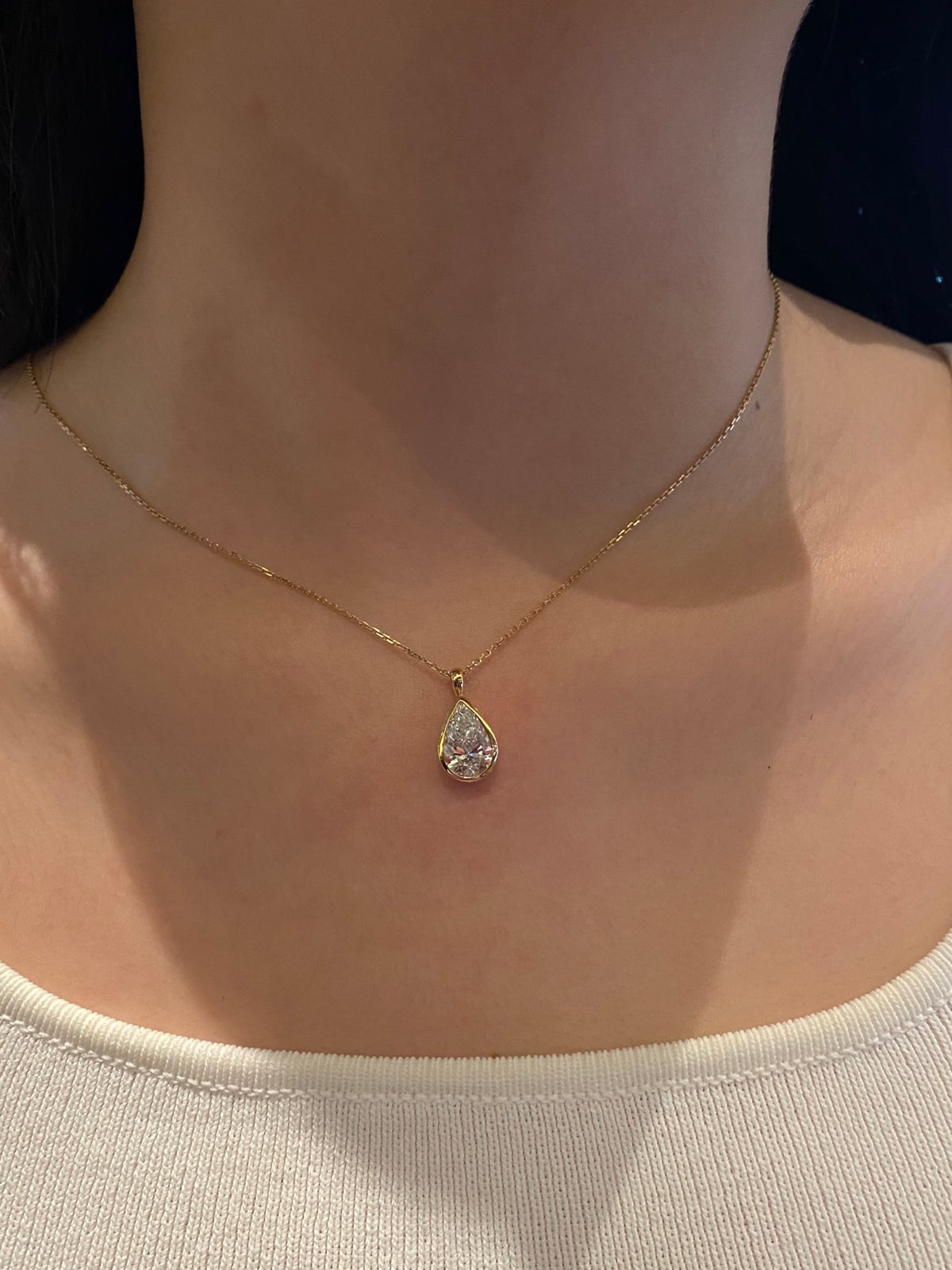 Pear bezel lab-grown diamond necklace in yellow metal, original wearing view 2
