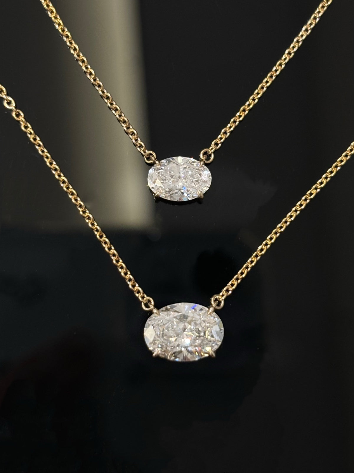 Two original sizes of yellow-metal east-west oval diamond necklaces for comparison, one necklace sold per unit