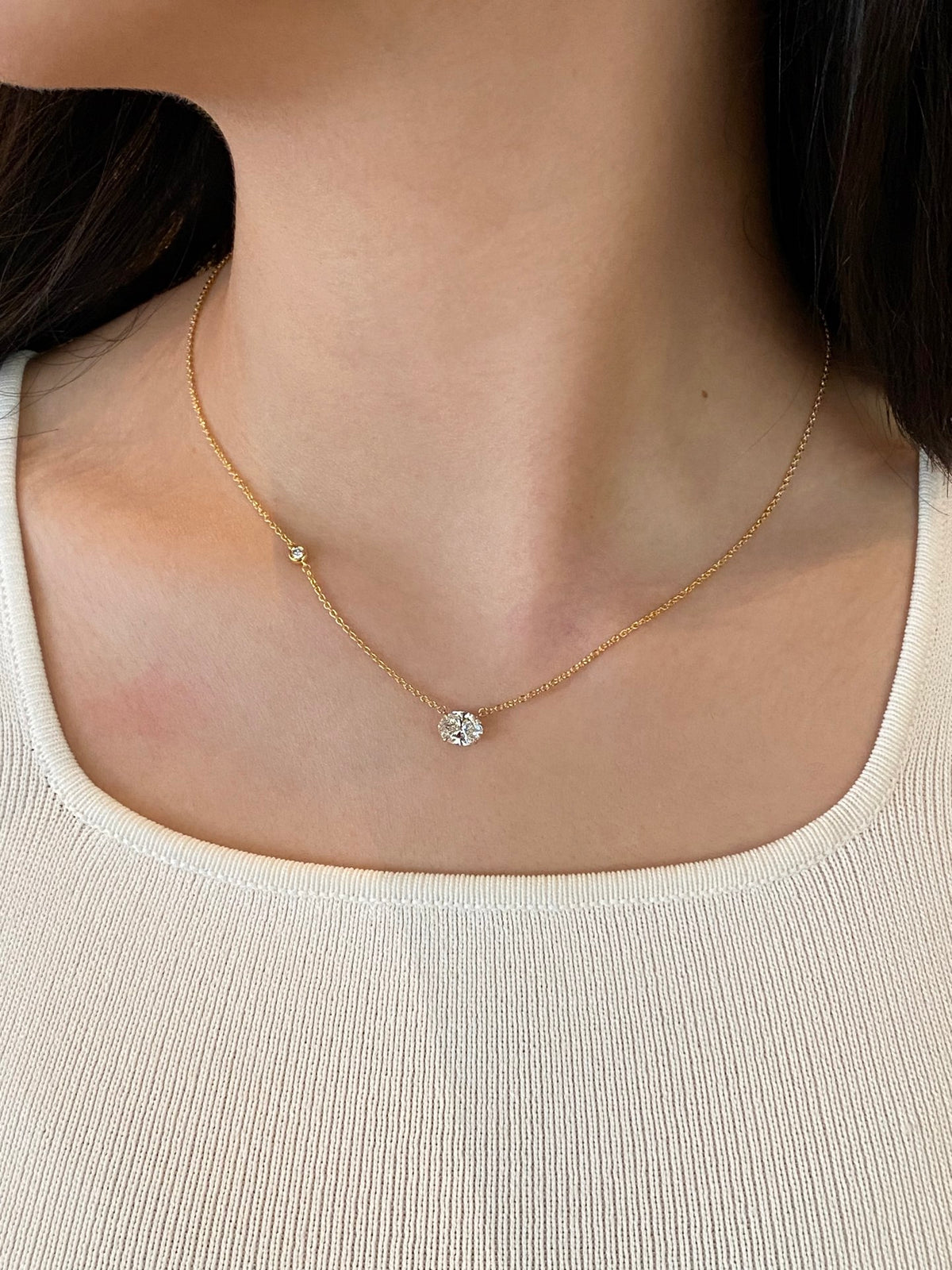 East-west oval lab-grown diamond necklace in yellow metal with one round accent, original wearing view