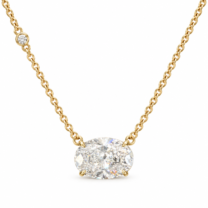 East-west oval lab-grown diamond necklace in 18K yellow gold with one round bezel accent, white background