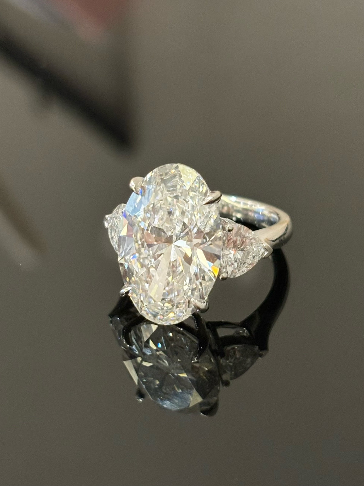 Oval lab-grown diamond ring with two heart-shaped side diamonds in white metal, original three-quarter view