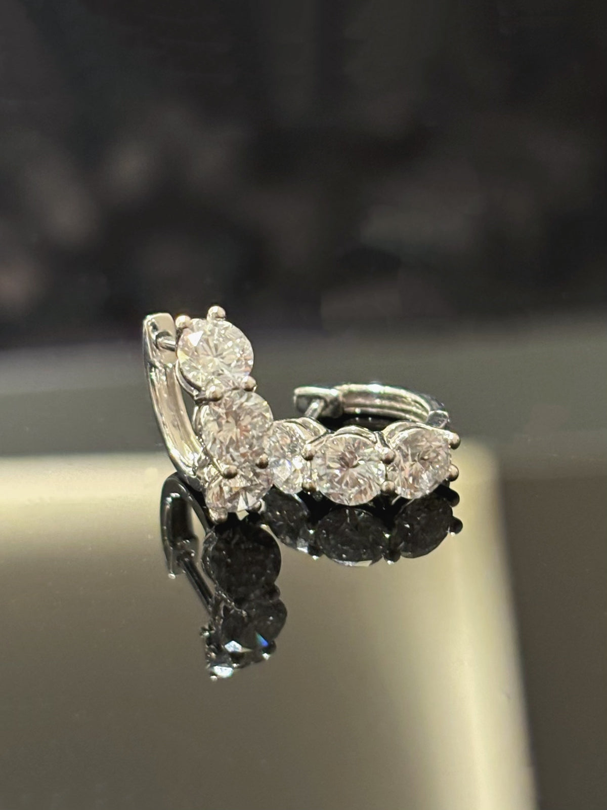Three-round-diamond hoop earrings in white metal, original angled pair view