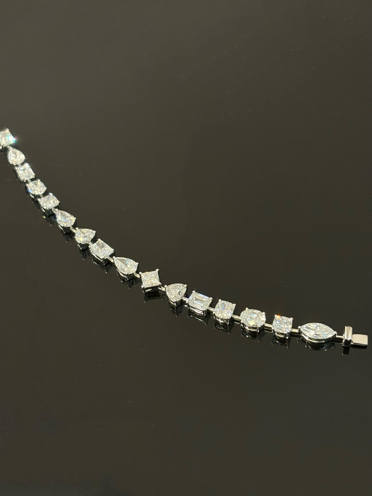Mixed-cut lab-grown diamond bracelet in white metal, original open-line view including clasp tongue