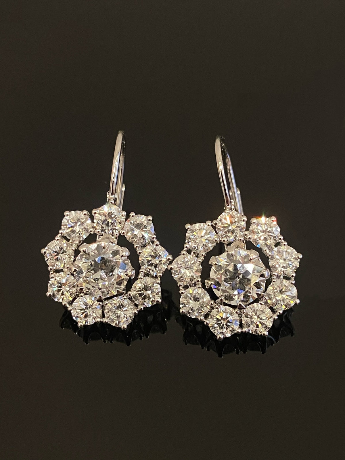 Old European-cut diamond drop earrings in white metal with flower-shaped round-diamond halos, original assembled pair