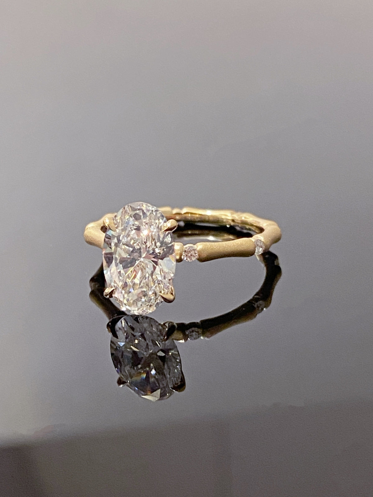 Oval lab-grown diamond bamboo-band ring in yellow metal, original angled view