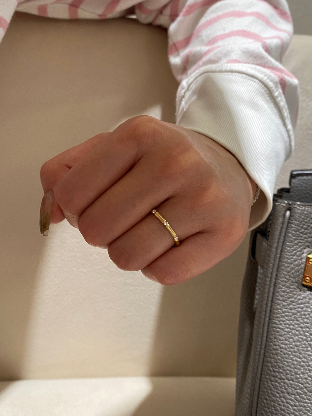Bamboo-inspired yellow-metal ring band with round diamond stations, original rear wearing view