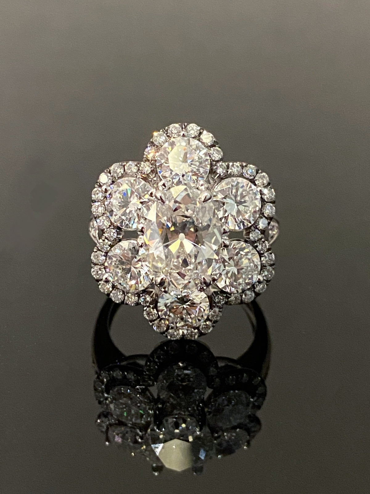 Antique-cut floral diamond ring in white metal with dark fine-diamond outline, original frontal view