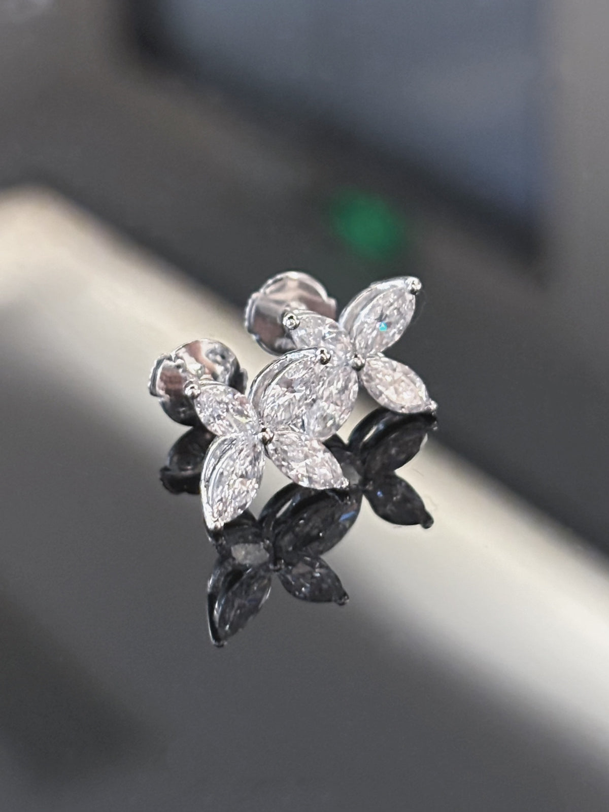 Four-petal marquise diamond stud earrings in white metal, original angled pair view