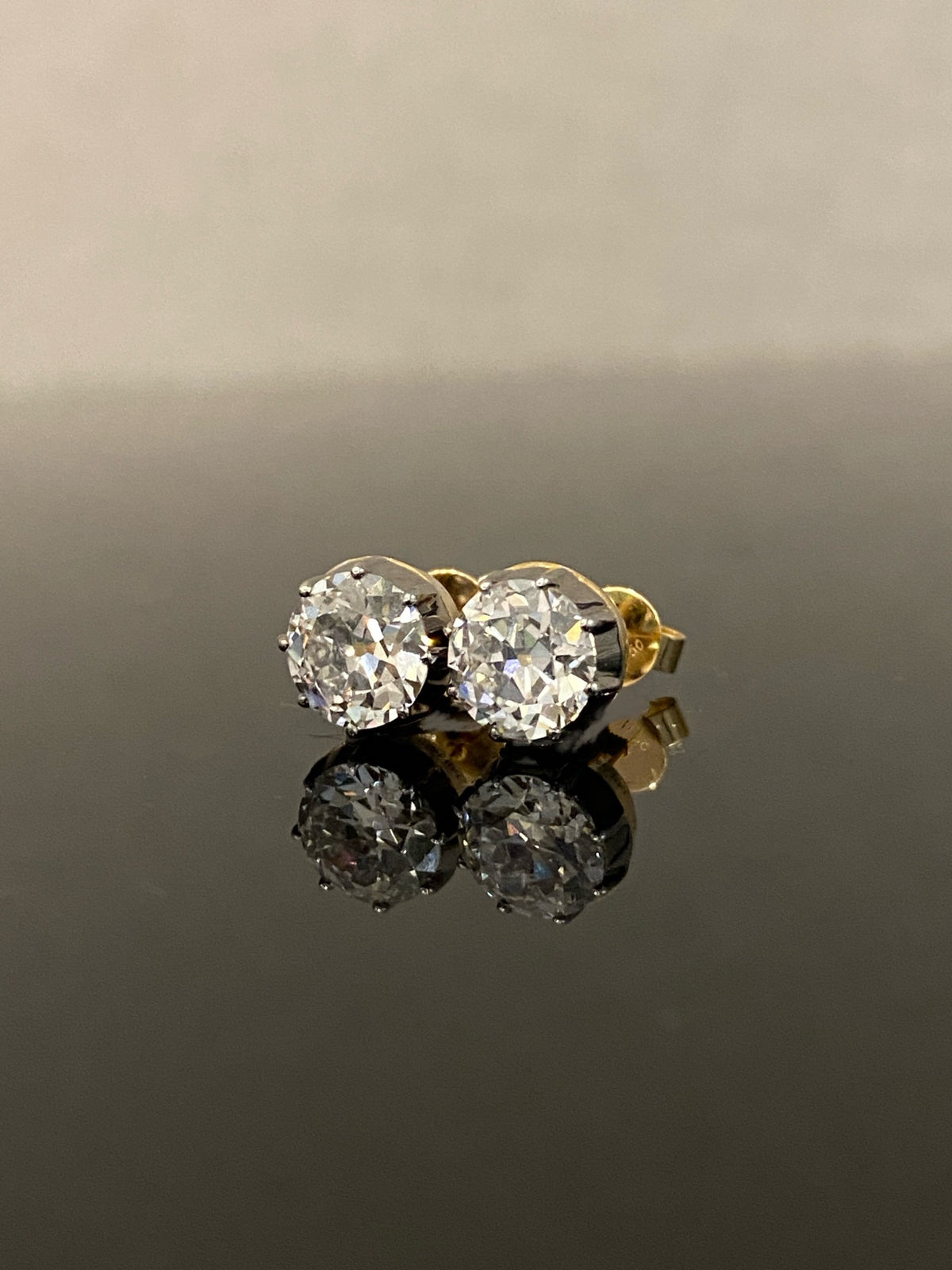 Old European-cut diamond stud earrings, original smaller-pair view with dark settings and yellow-gold rear details
