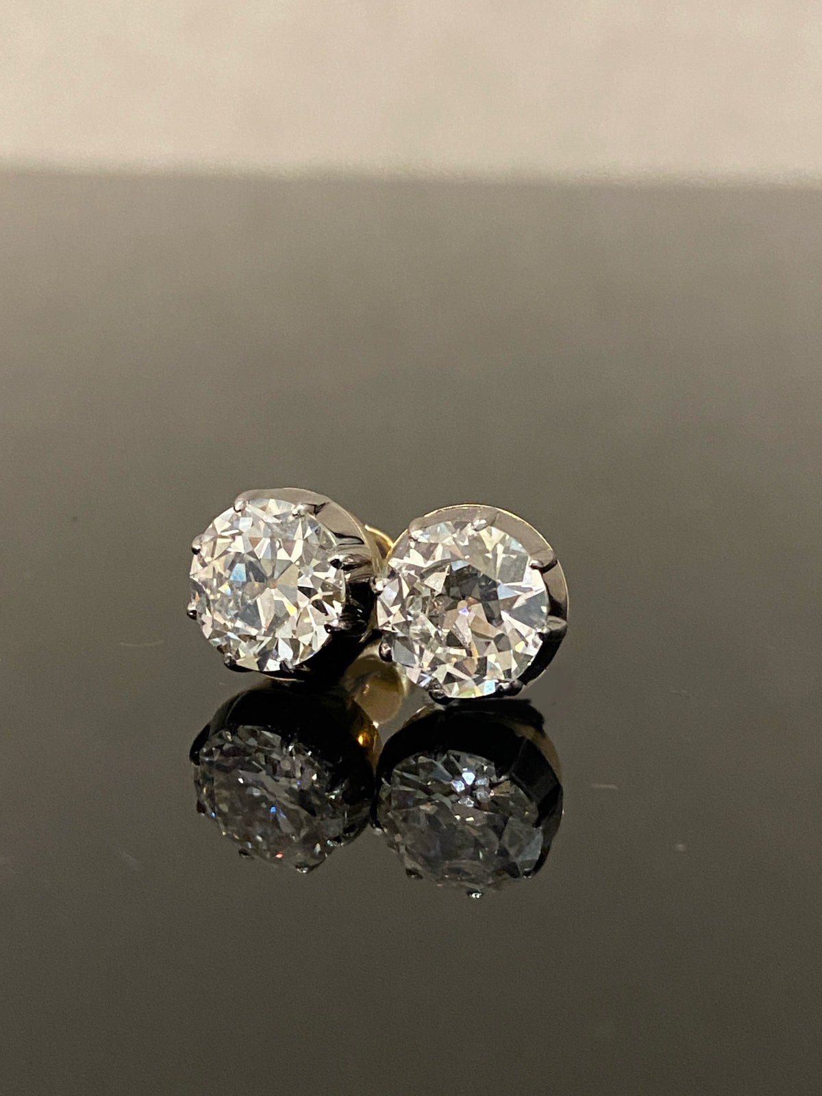 Old European-cut diamond stud earrings, original larger-pair view with dark settings and yellow-gold rear details