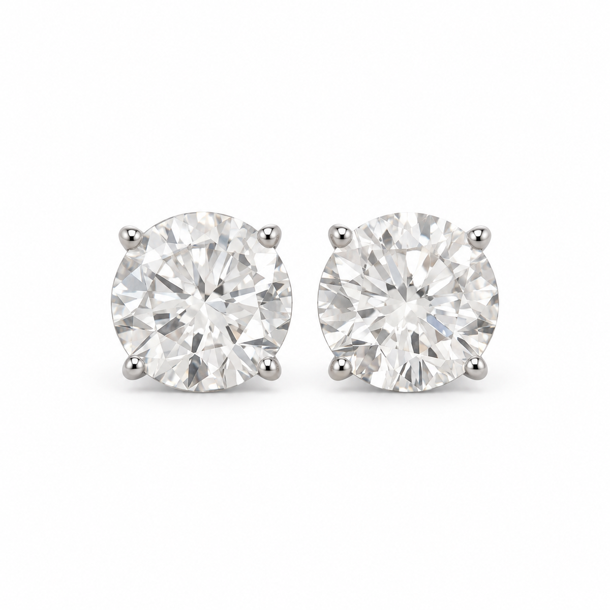 Round lab-grown diamond stud earrings in 18K white gold, complete four-prong pair on white background