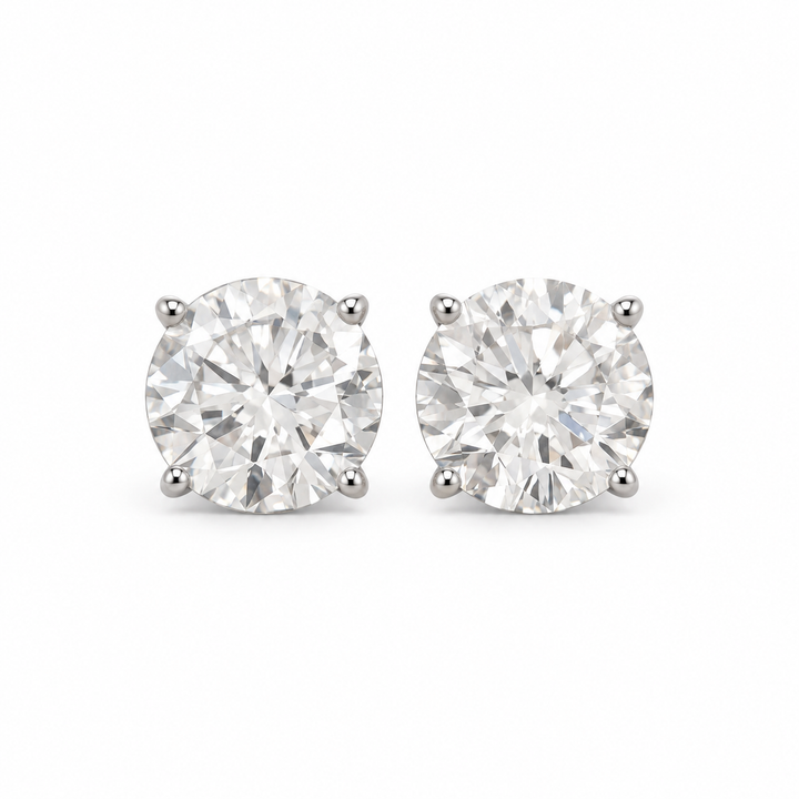 Round lab-grown diamond stud earrings in 18K white gold, complete four-prong pair on white background