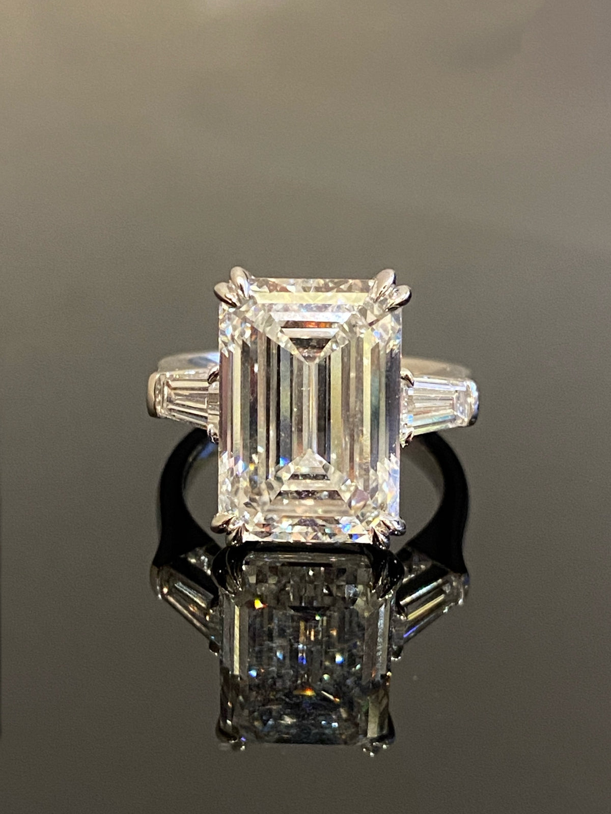 Emerald-cut three-stone diamond ring, original frontal view with double corner prongs and tapered baguette sides