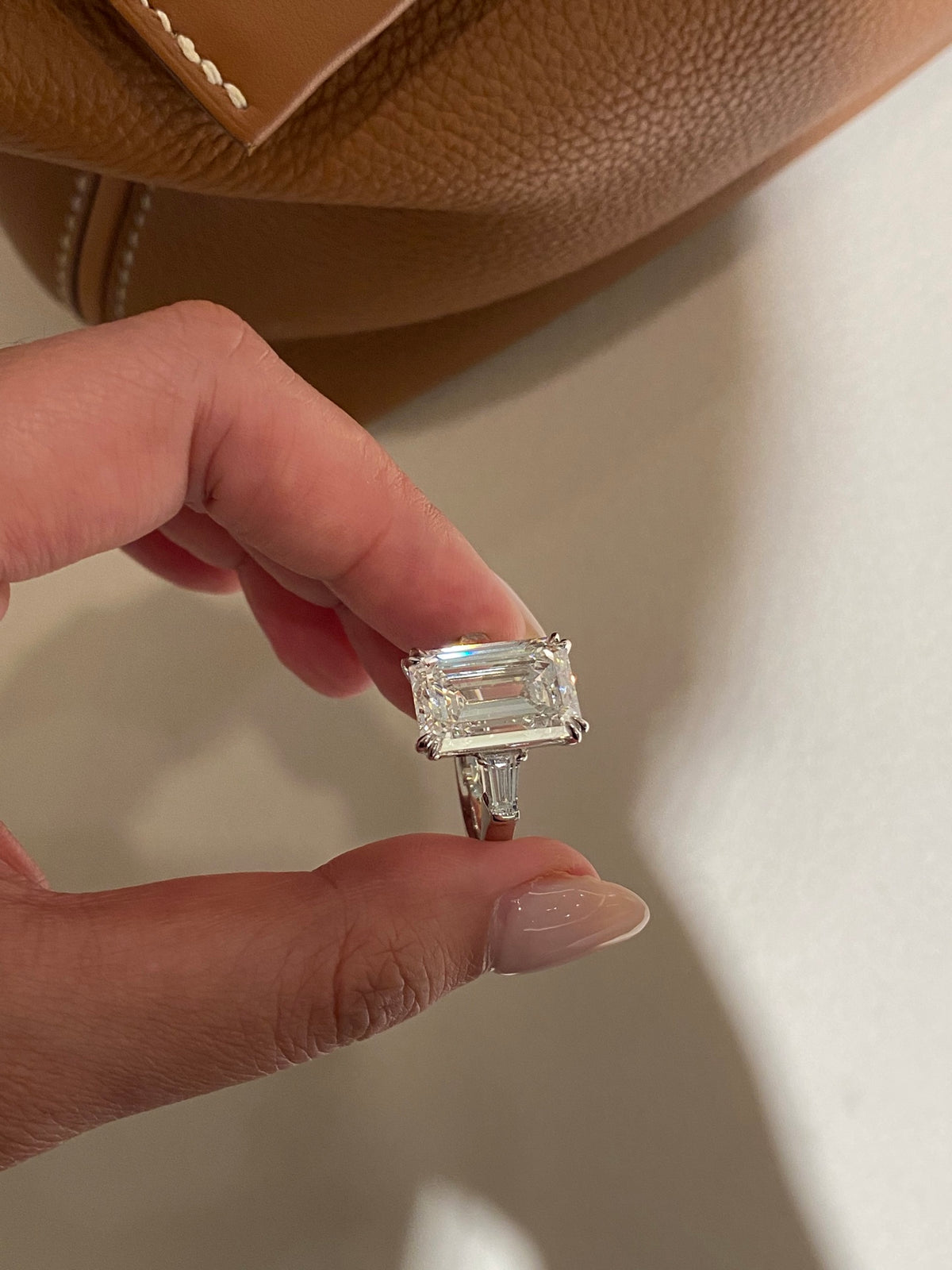 Emerald-cut diamond ring with tapered baguette sides, original held angle