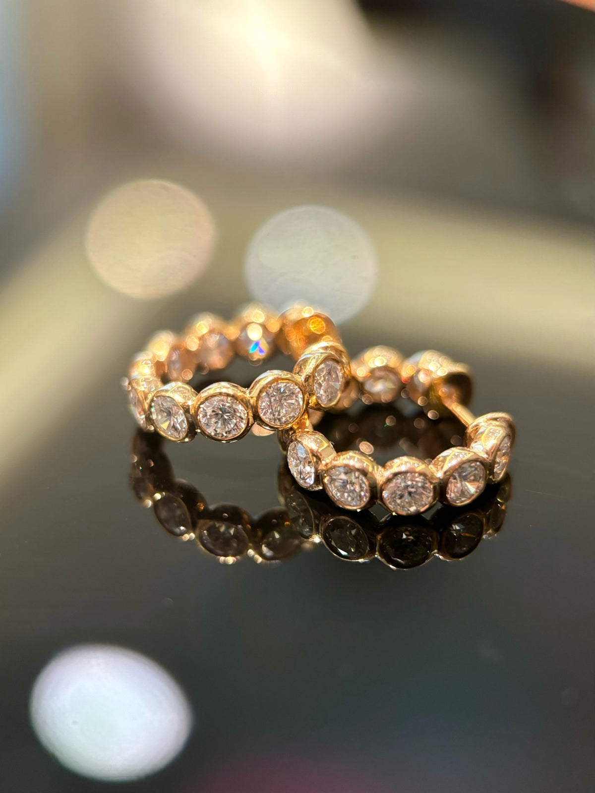 Round bezel-set diamond hoop earrings in yellow gold, original laid pair view
