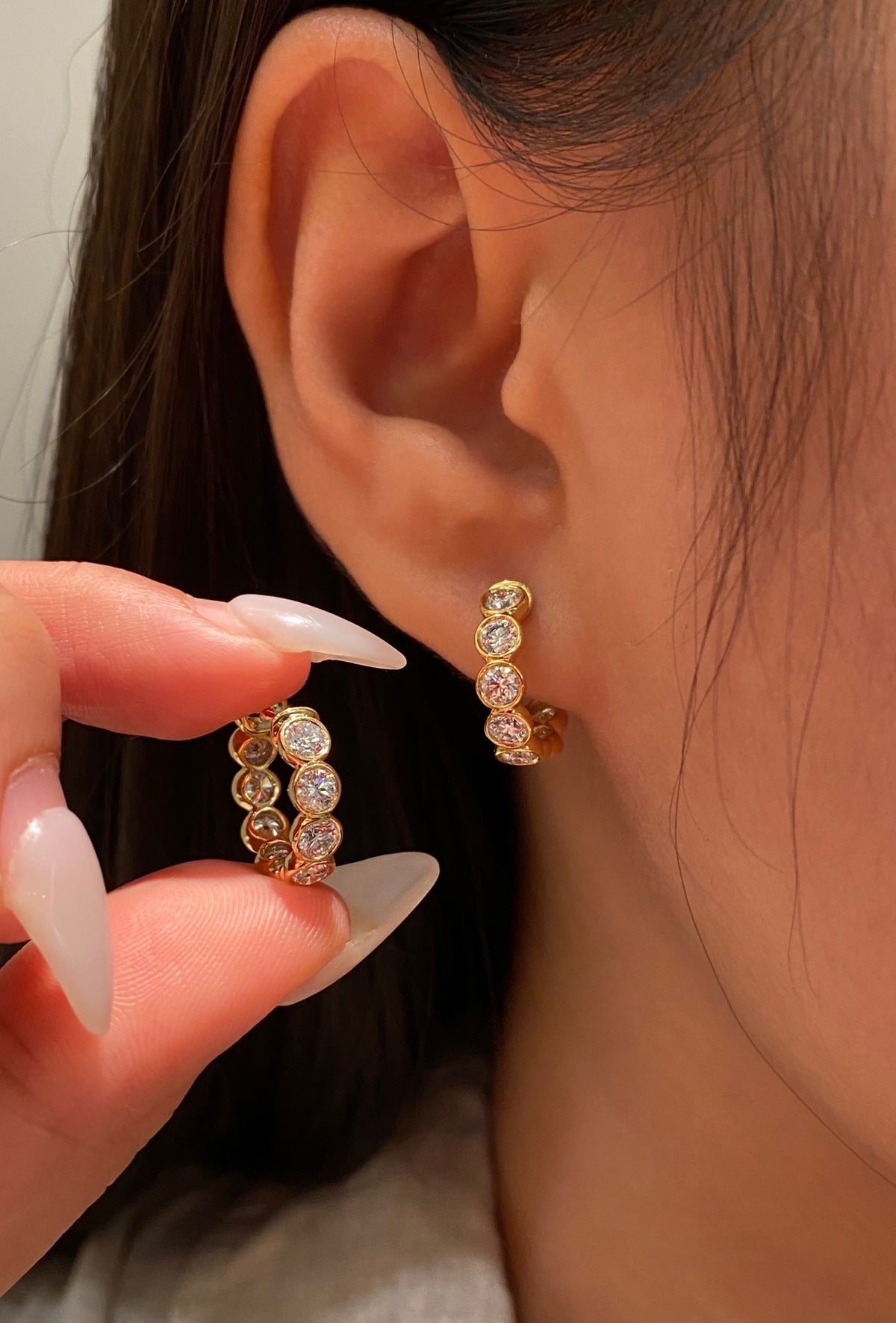 Round bezel-set diamond hoops in yellow gold, original wearing view 1