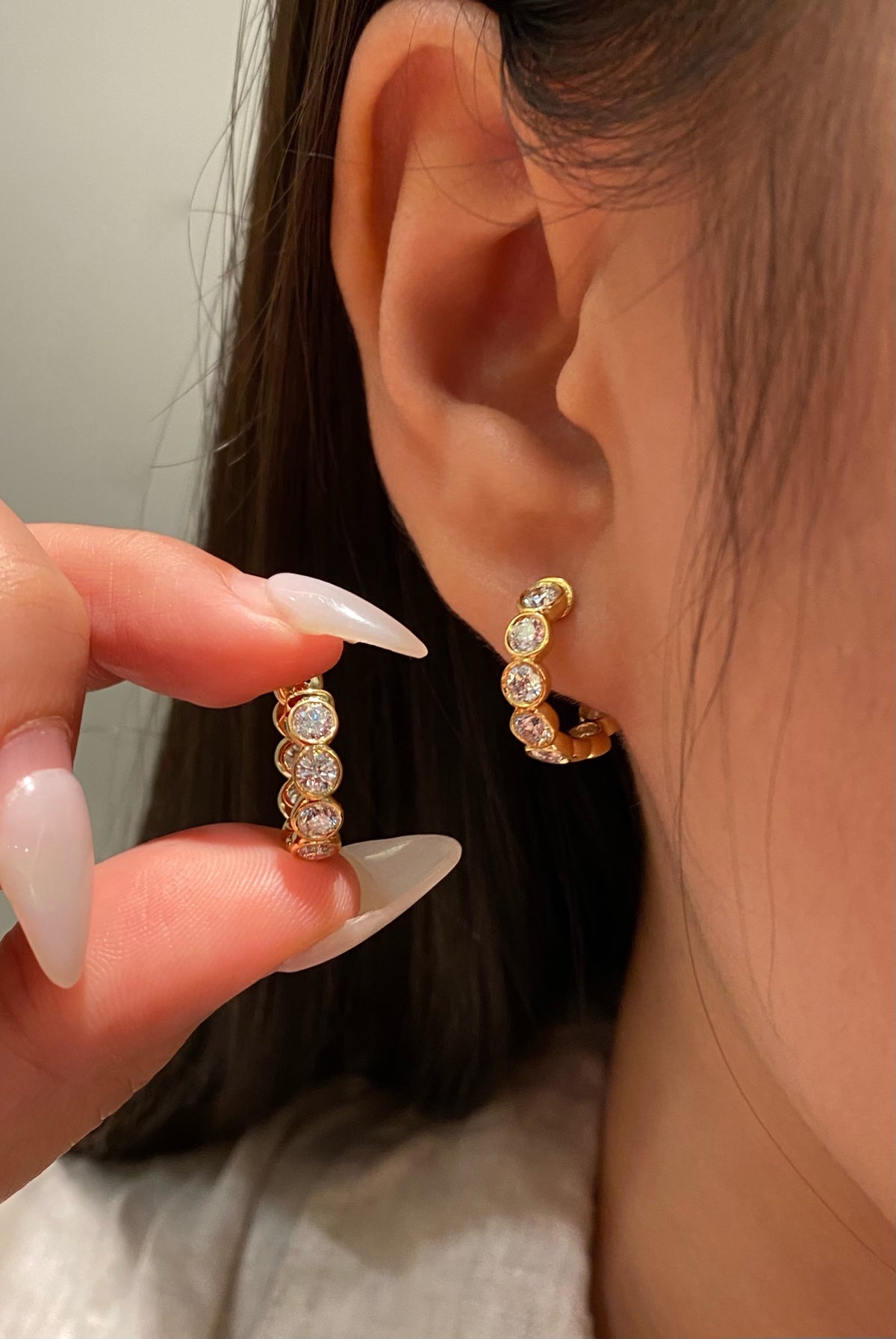 Round bezel-set diamond hoops in yellow gold, original wearing view 2