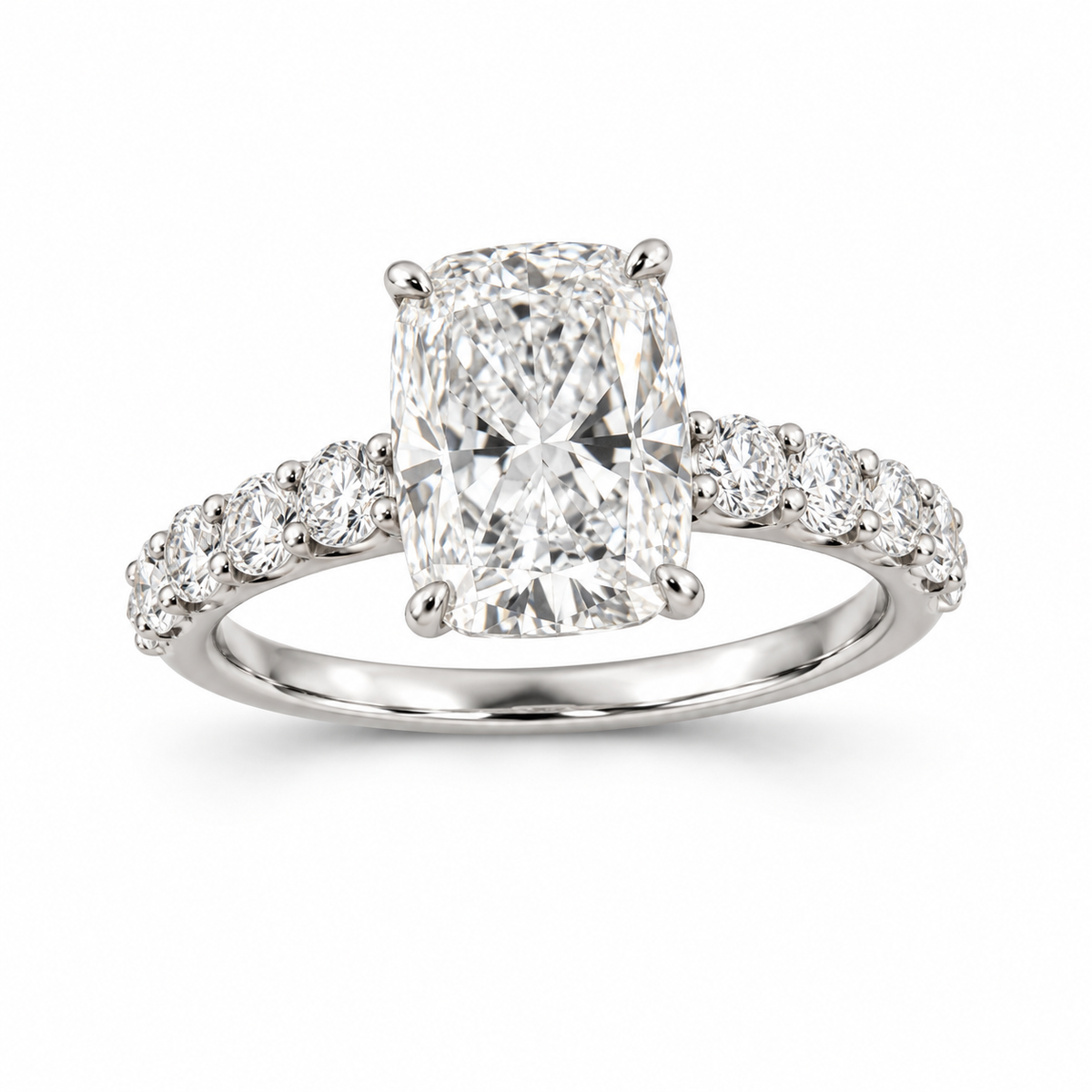 Elongated cushion lab-grown diamond ring in 18K white gold with four corner prongs and round diamond shoulders on white