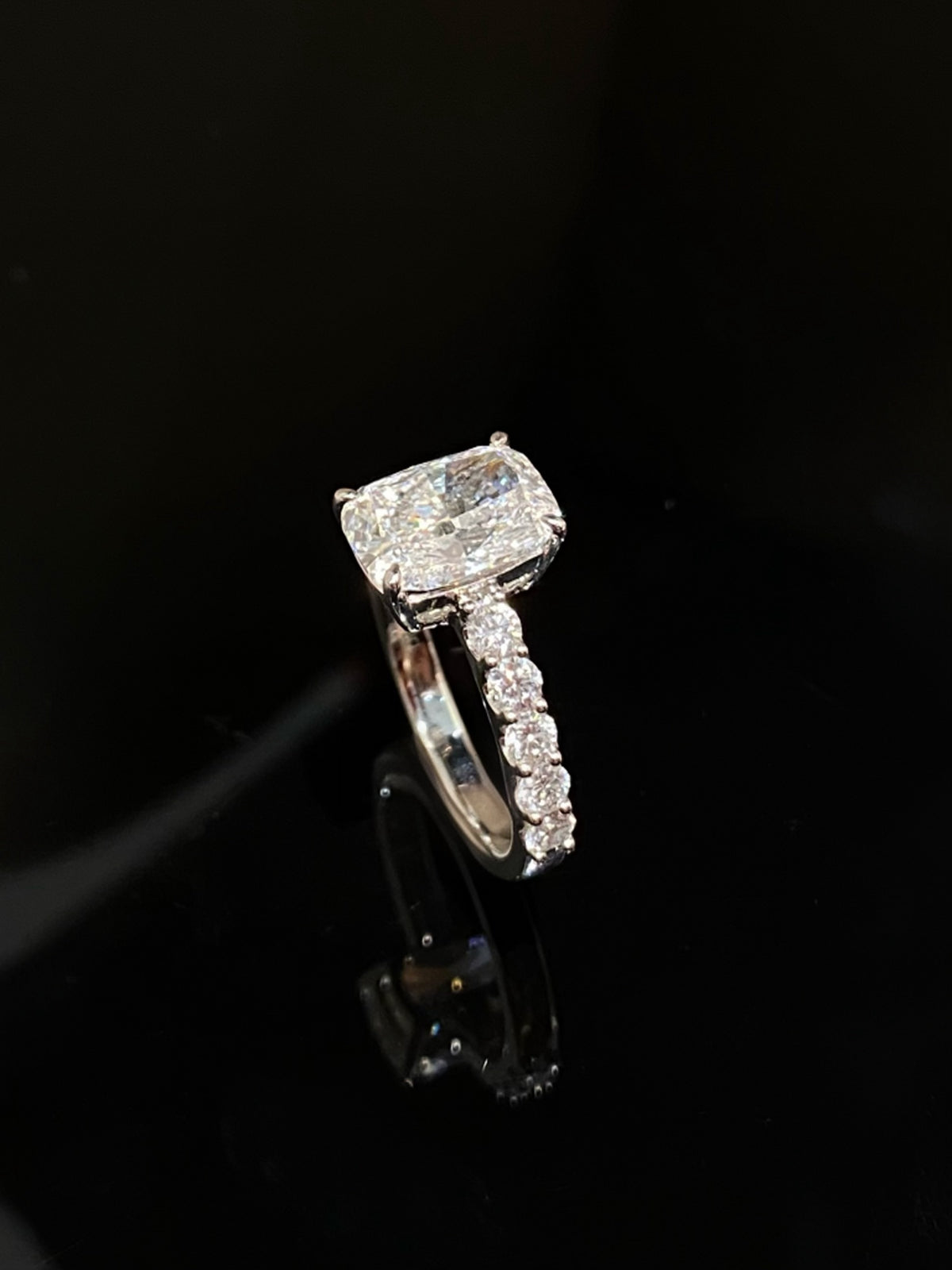 Elongated cushion diamond ring with round diamond shoulders, original white-gold side view