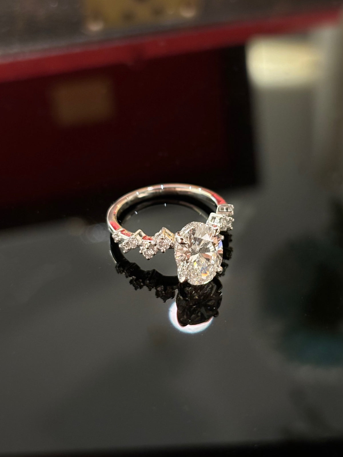 Oval diamond ring with geometric diamond-set shoulders, original white-gold angled view