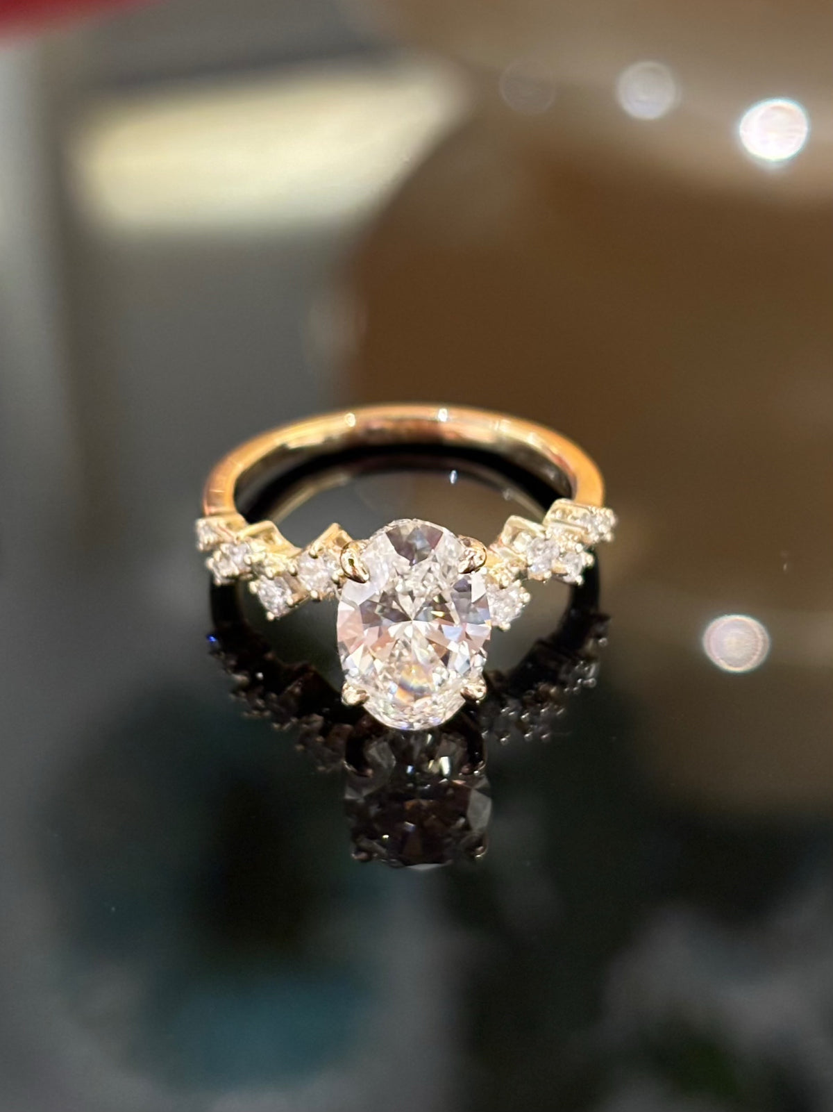 Oval diamond ring with geometric diamond-set shoulders, original yellow-gold frontal view