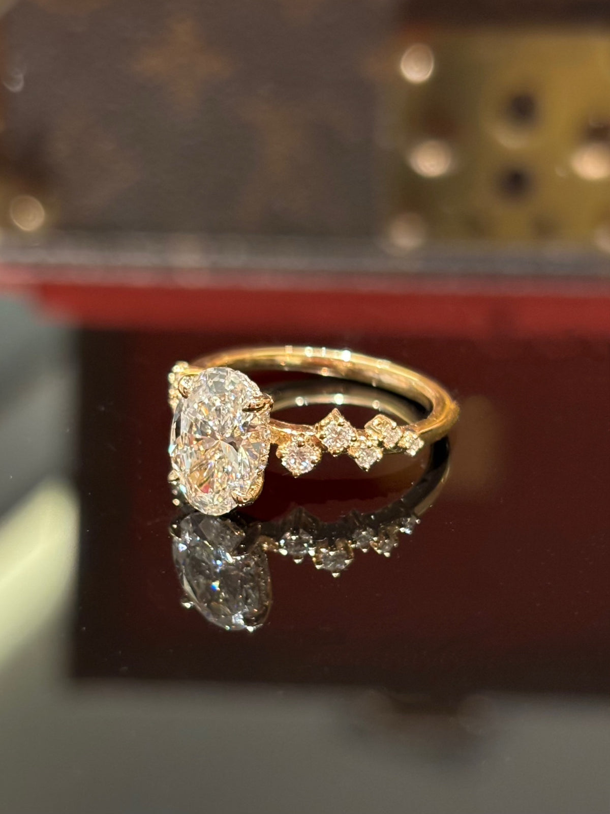Oval diamond ring with geometric shoulders, original yellow-gold angled view