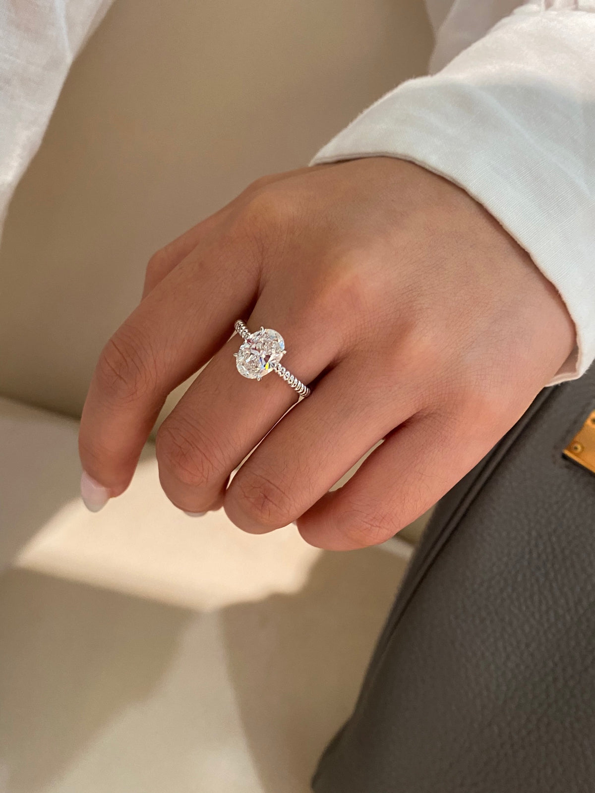 Oval diamond rope-band ring in white platinum, original wearing view 1; other jewelry not included