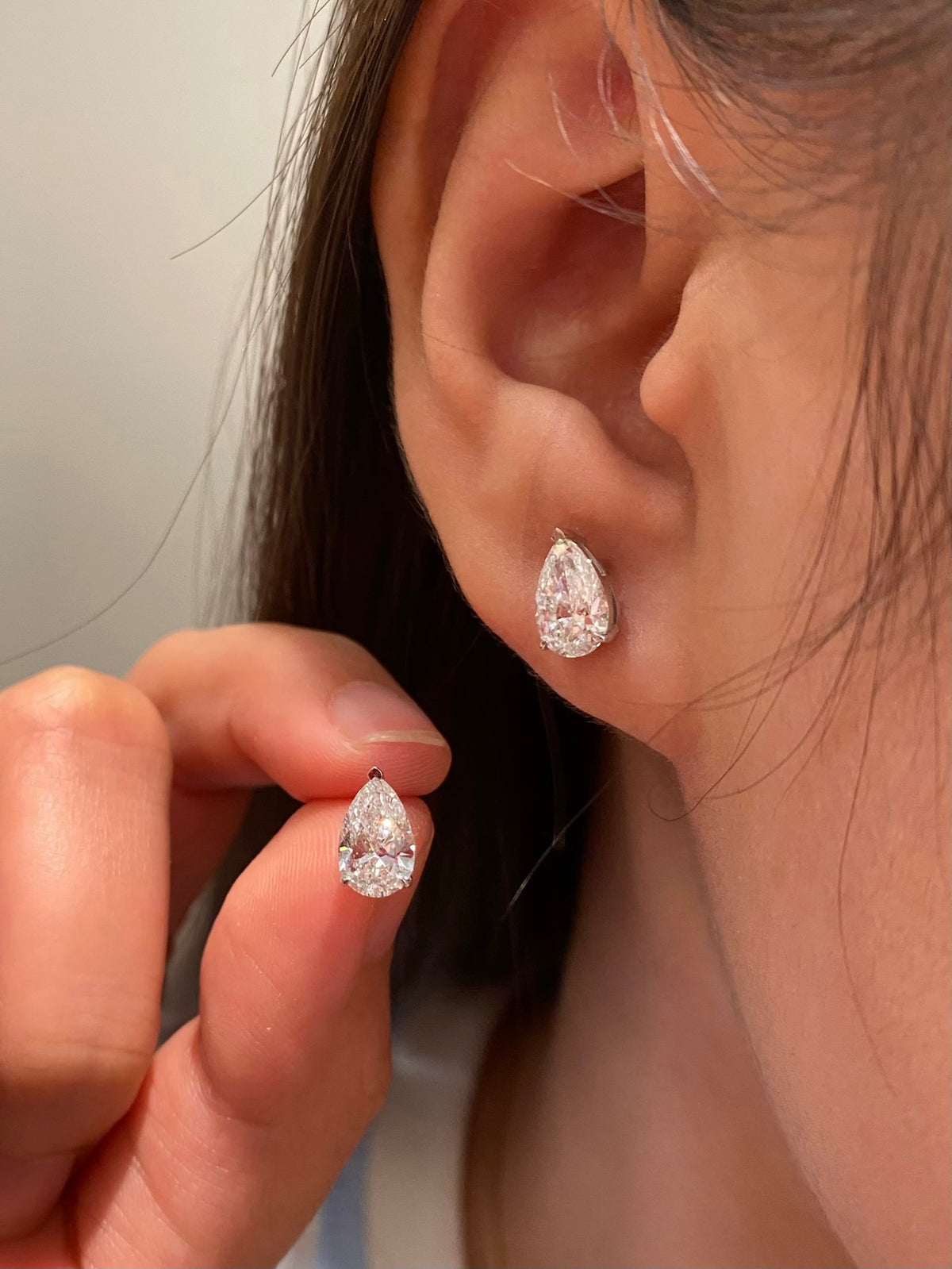 Pear-cut diamond stud earrings in white gold, original wearing view 1