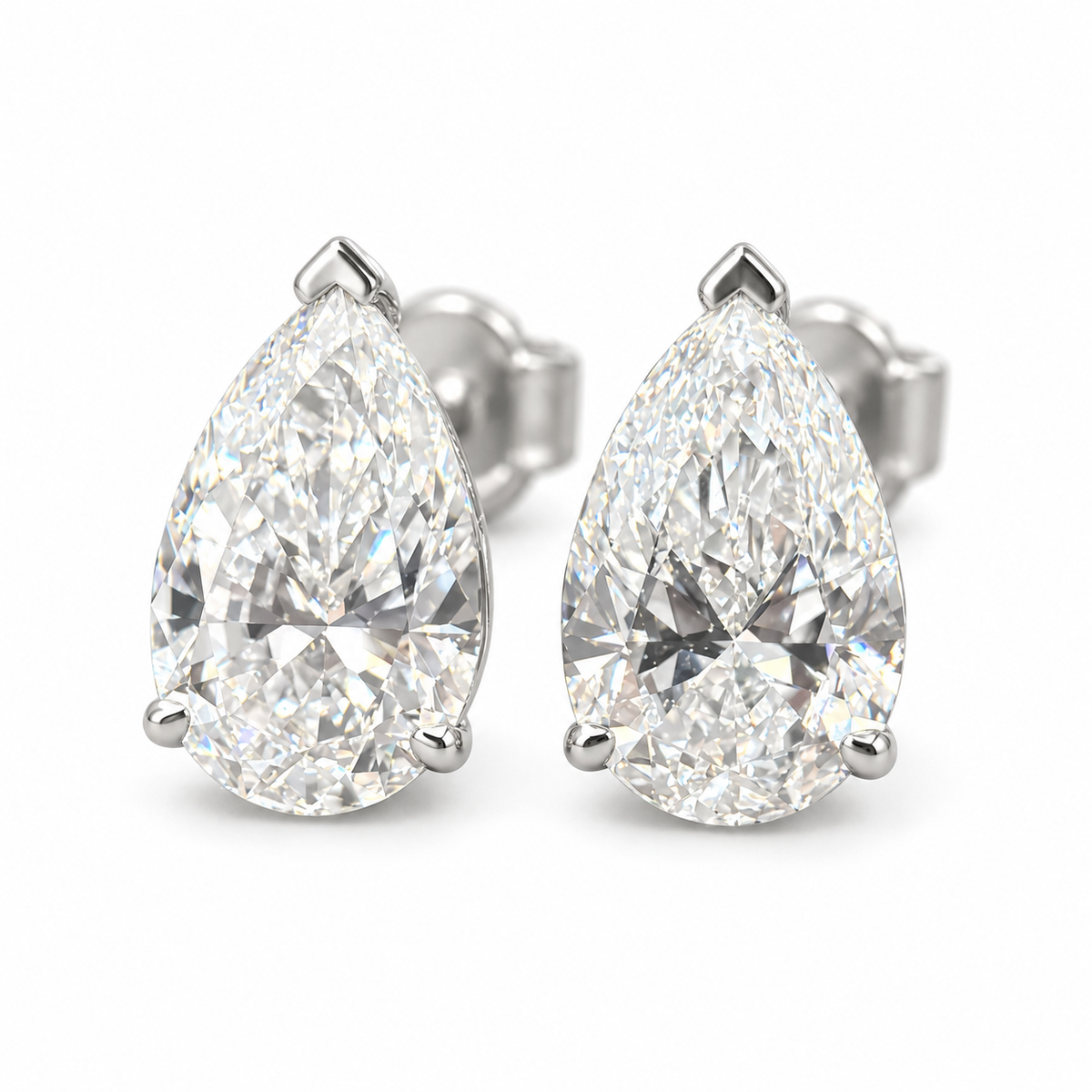 Pair of pear-cut lab-grown diamond stud earrings in 18K white gold with protective tip prongs and butterfly backs on white