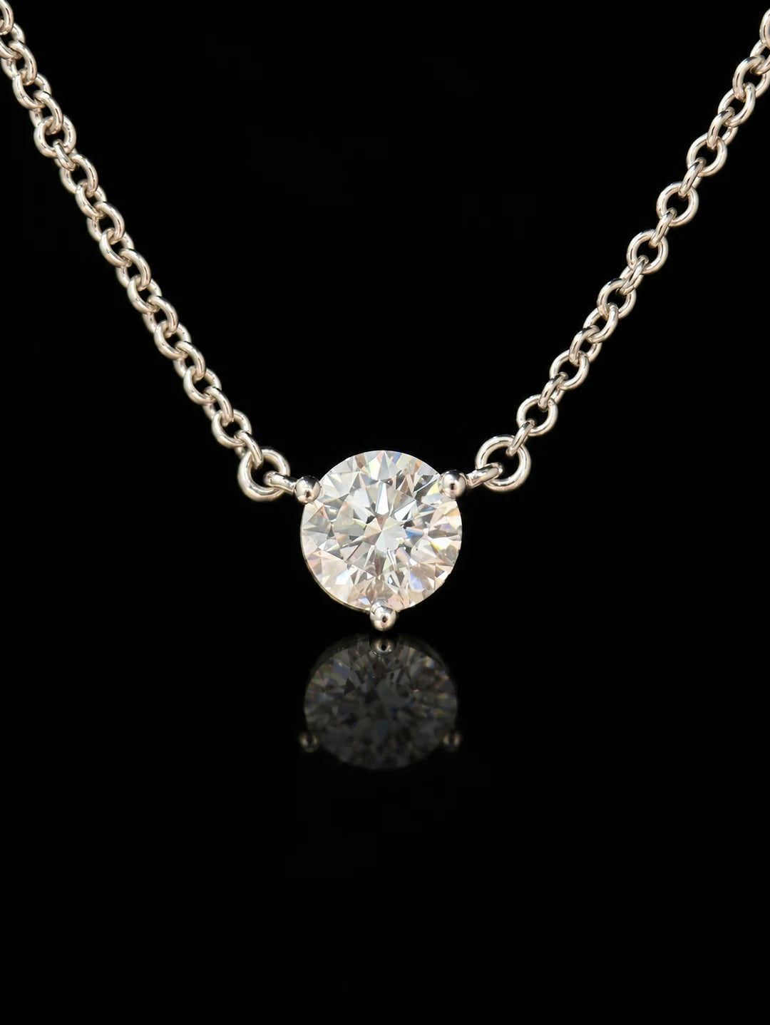Round solitaire necklace on black mirrored glass