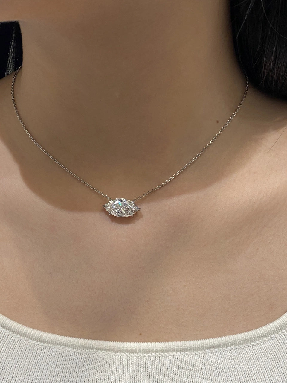 A horizontal clear-stone pendant worn on a fine chain.